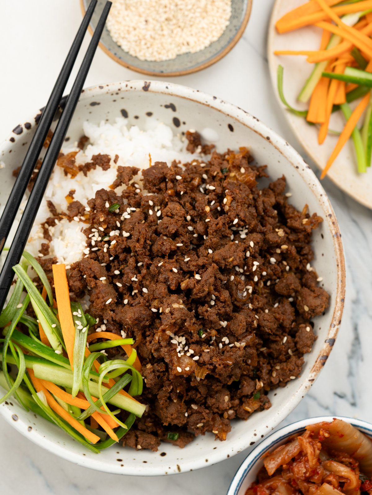 Korean beef bulgogi served over a bread of rice and a side of Kimchi