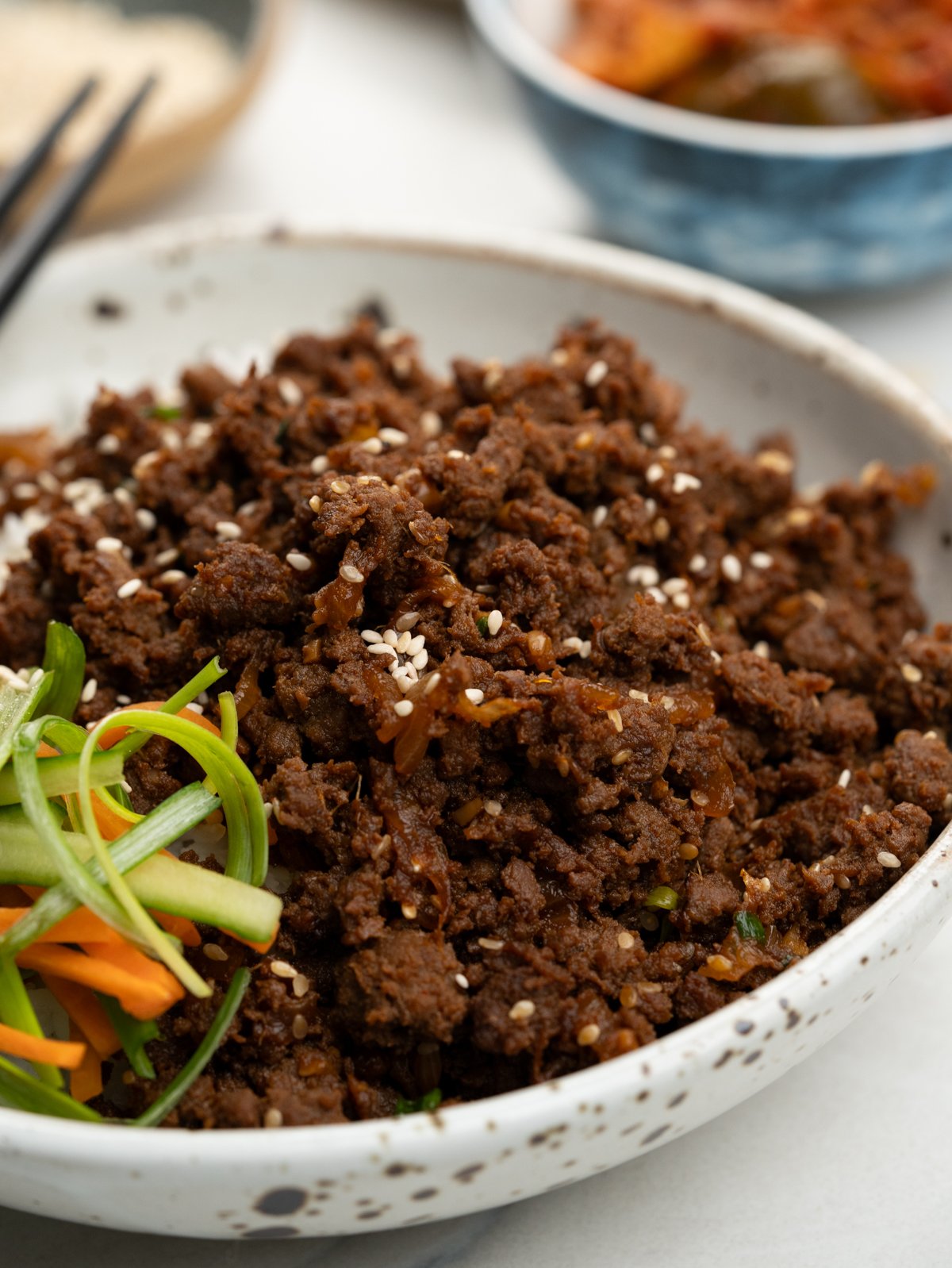 Korean Beef Bulgogi garnished with toasted sesame seeds and chopped spring onions.