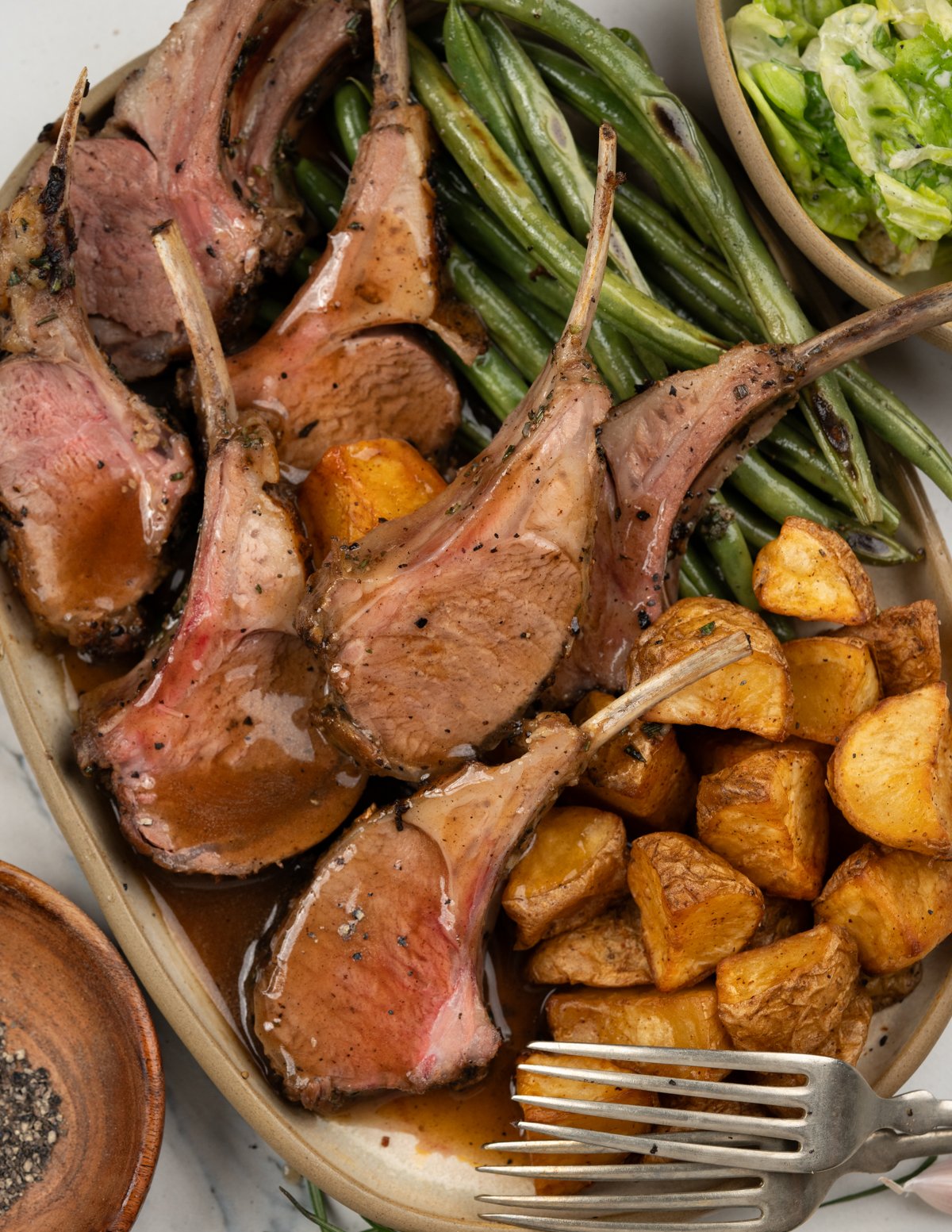 Carved lamb chops from a rack of lamb and served with gravy.