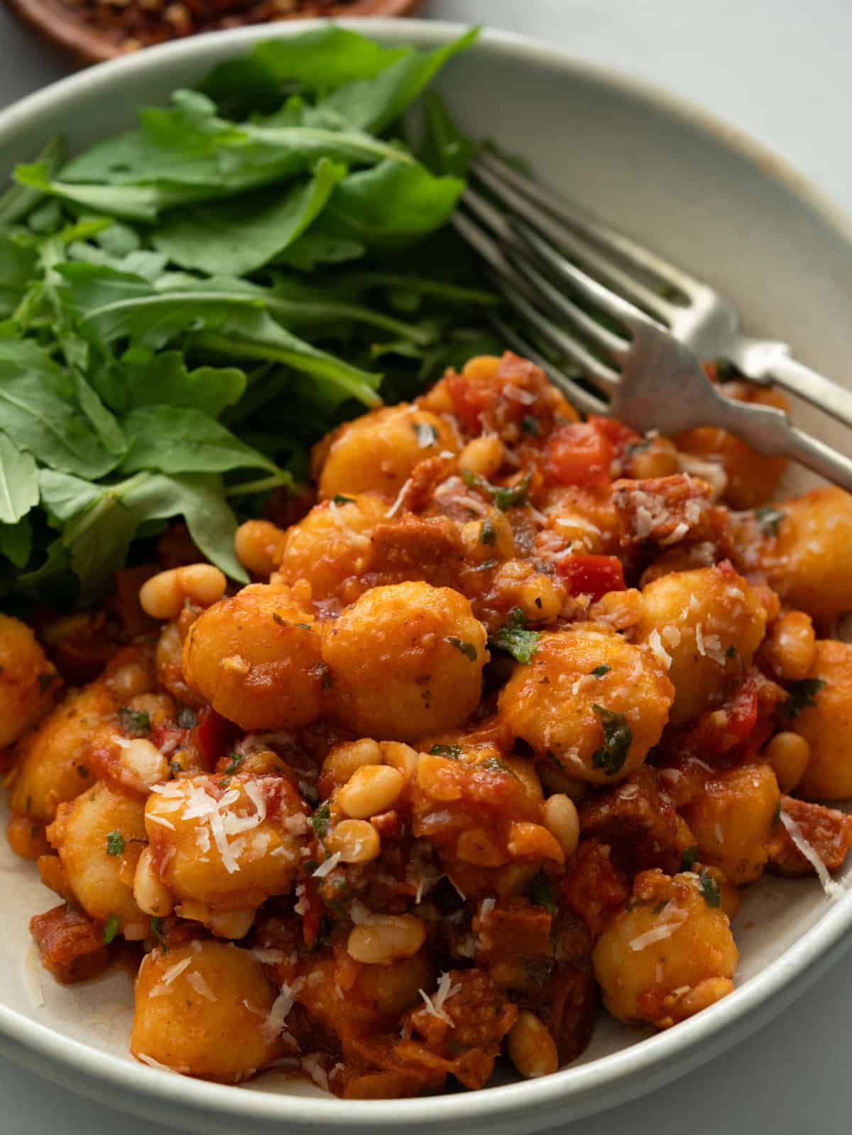Close up of chorizo gnocchi with white bean.